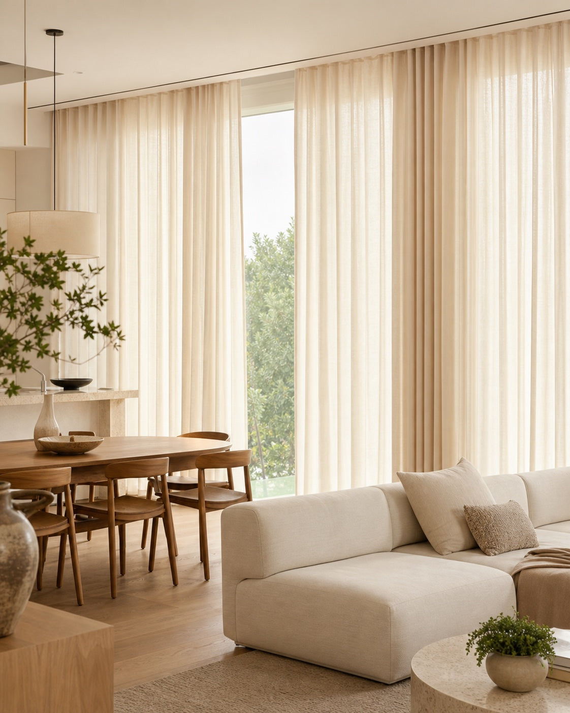 Open-plan dining room with warm ivory floor-to-ceiling curtains